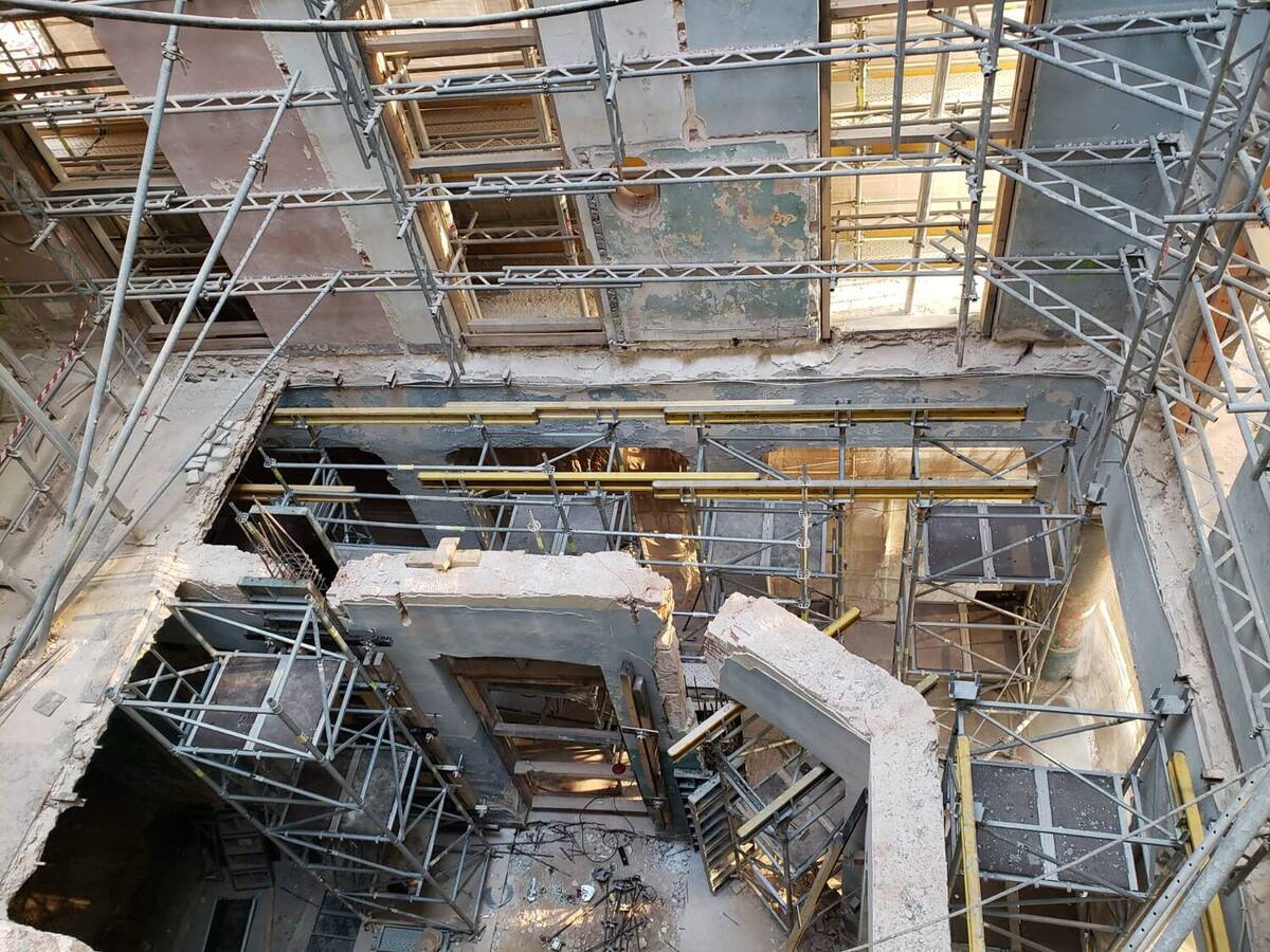 Cour intérieure d'un bâtiment étrésillonnée par un réseau de tubes métalliques pendant les travaux de curage.